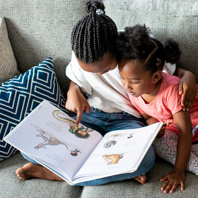 two sisters reading a book