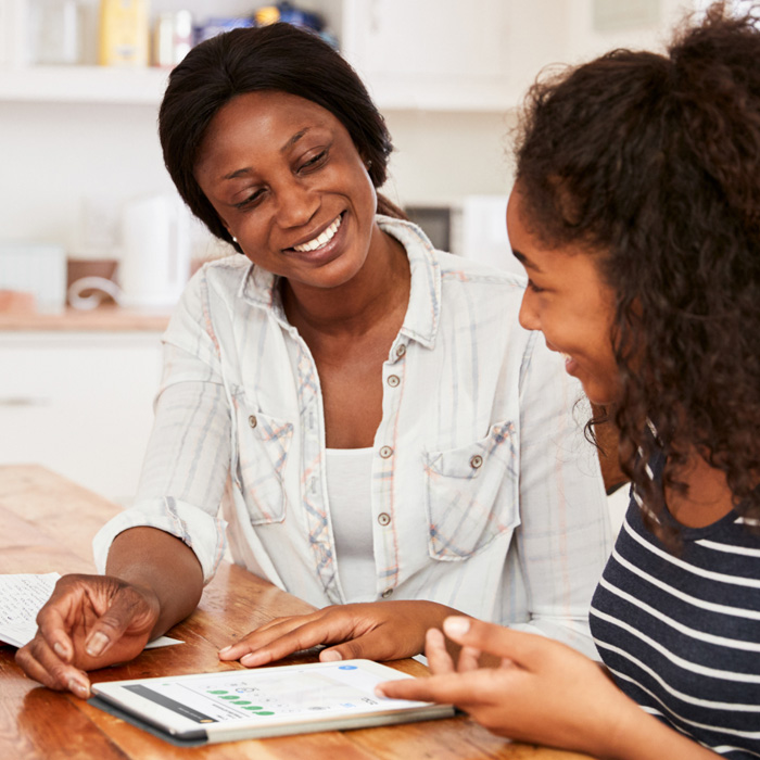 adult and teenager looking at a tablet