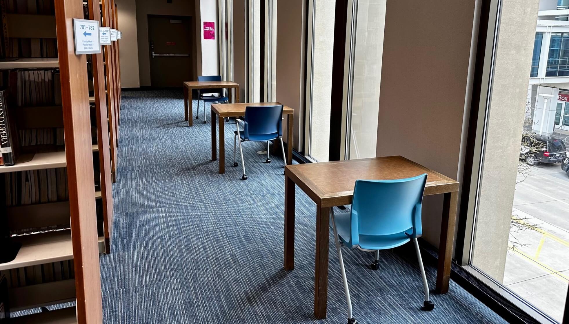 3 small tables with chairs next to large windows