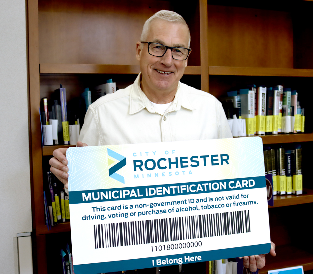 Council member Palmer holding a large Library Municipal ID Card